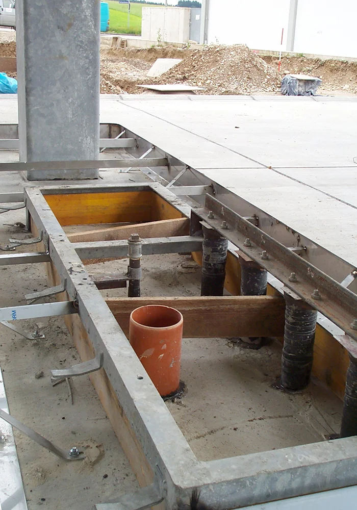 Fundamentbereich mit Anschlüssen und Rohrleitungen unter Betonplatte auf Baustelle