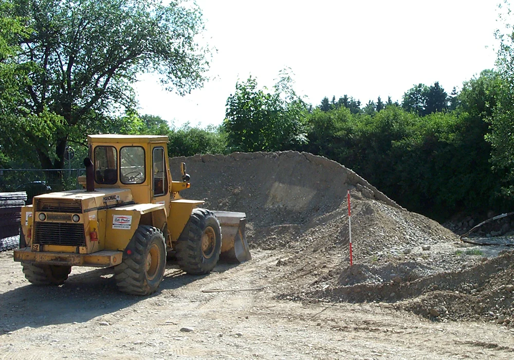 Radlader bewegt Kieshaufen auf Baustelle für Erdarbeiten am Gewerbebau