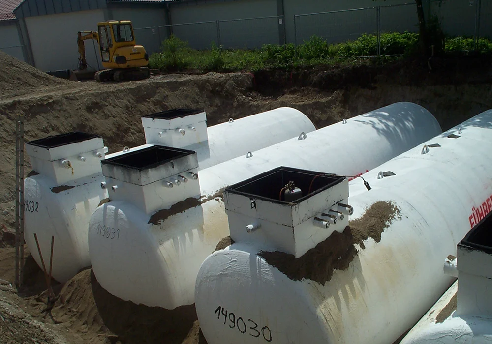 Mehrere unterirdische Kraftstofftanks werden in Baugrube für Tankanlage eingesetzt