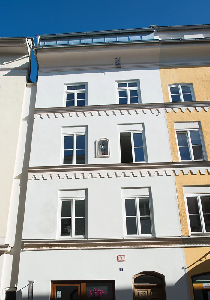Sanierte historische Altstadtfassade mit Stuckelementen und Mariennische in Wasserburg am Inn