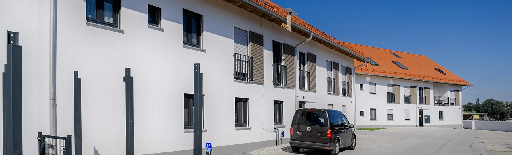 Zwei Mehrfamilienhäuser mit Dachfenstern und weißer Putzfassade