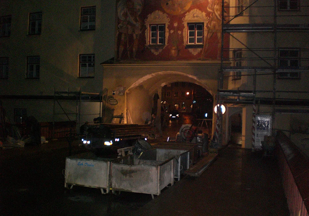 Nächtliche Bauarbeiten am Brucktor Wasserburg mit Gerüst, Containern und beleuchteter Durchfahrt