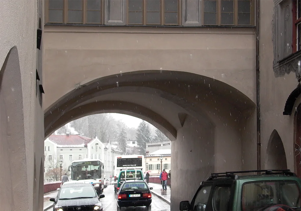 Durchfahrt unter saniertem historischem Brucktor mit Verkehr bei winterlichem Wetter