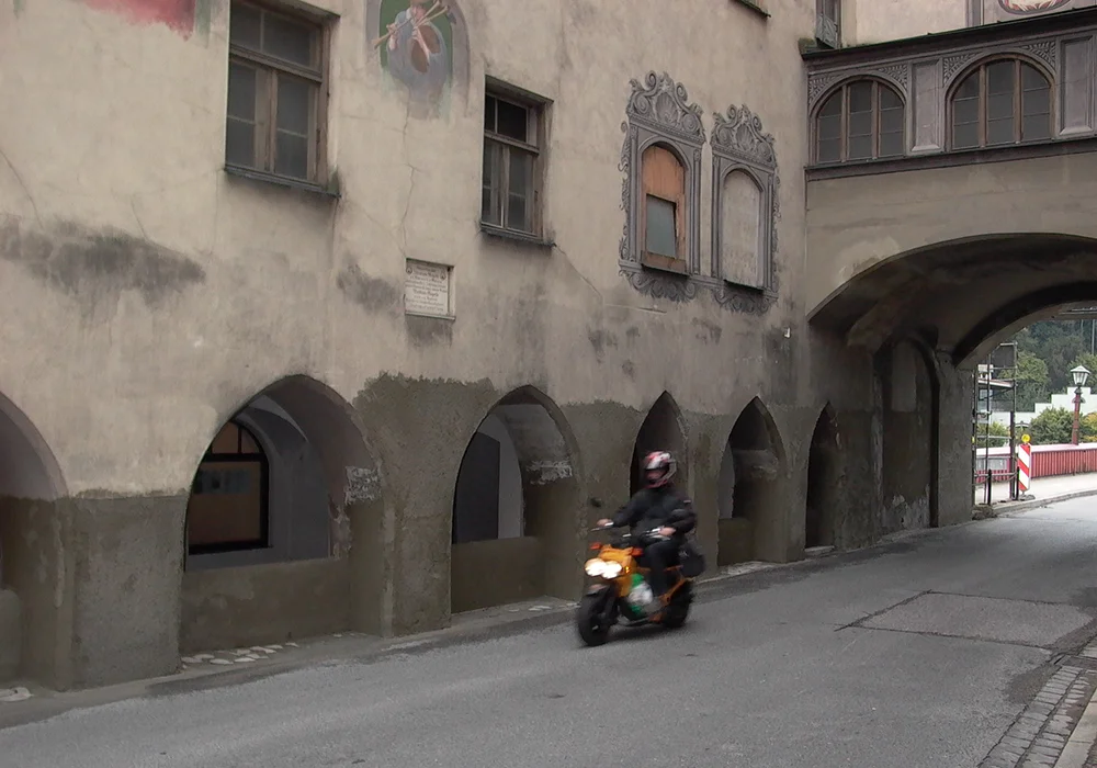 Straßenansicht des historischen Brucktors mit Arkaden und Durchfahrt durch das Stadttor