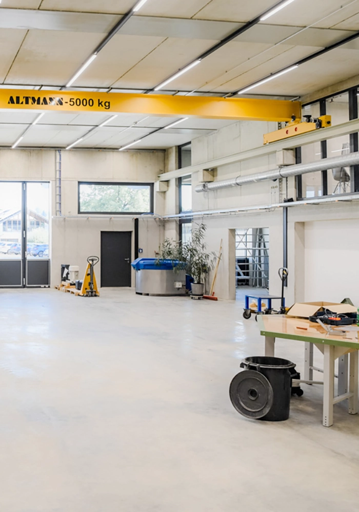 Innenraum der Werkhalle mit Hallenkran, Werkbänken und industrieller Ausstattung