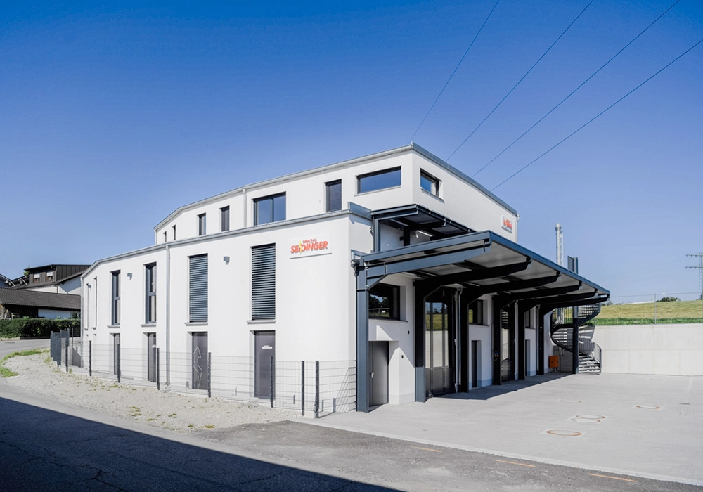 Modernes Gewerbegebäude mit überdachtem Eingangsbereich und großen Hallentoren