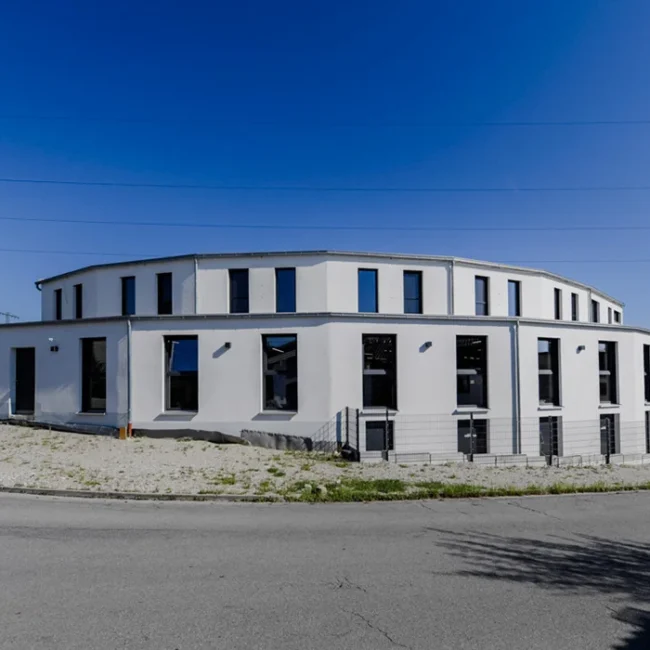 Gebäudeansicht eines modernen Gewerbebaus entlang einer Straßenkurve