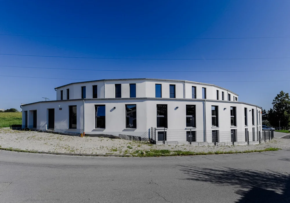 Gebäudeansicht eines modernen Gewerbebaus entlang einer Straßenkurve