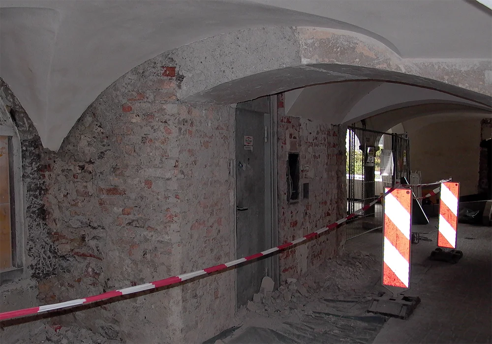 Freigelegte Ziegelwand und Gewölbe im Durchgang während Sanierungsarbeiten im historischen Gebäude