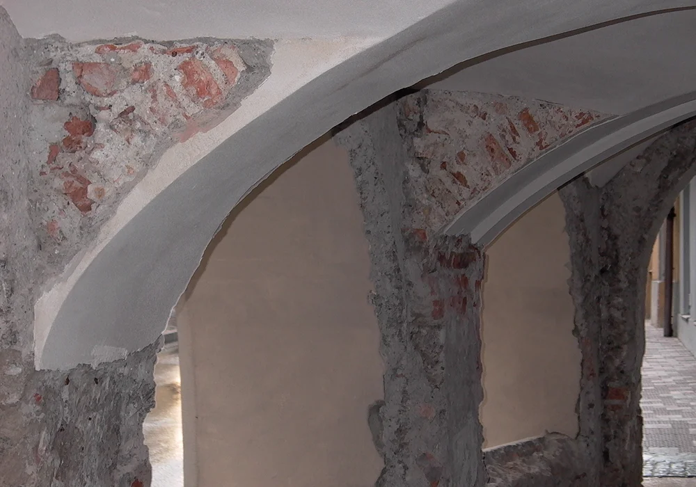 Freigelegte Gewölbebögen mit ausgebesserten Putzflächen bei Restaurierung der historischen Bausubstanz