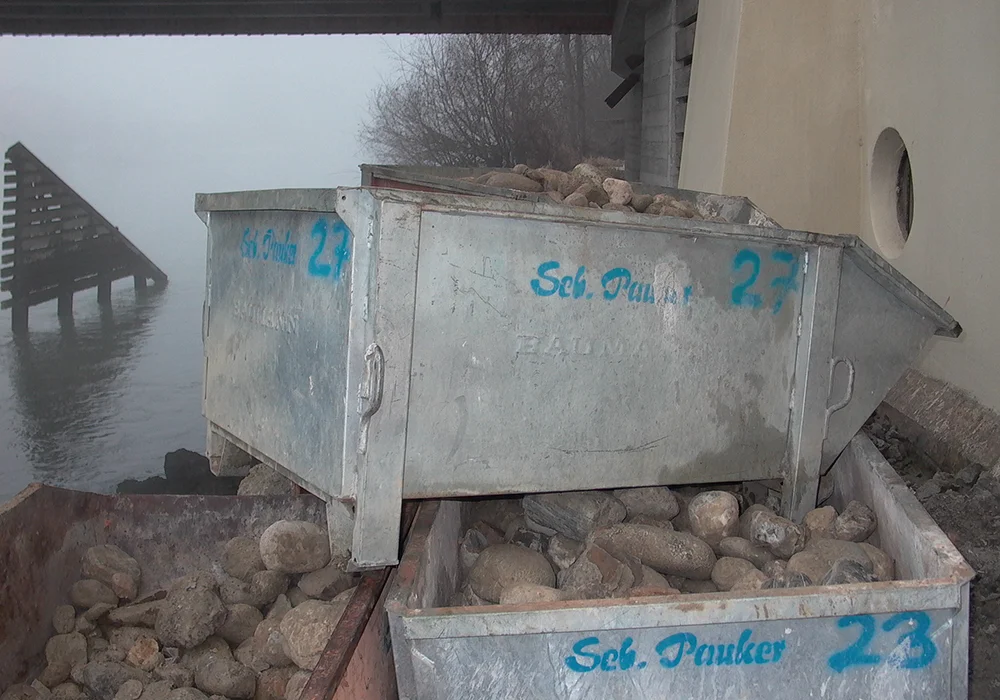 Metallcontainer mit ausgebautem Flusssand aus dem Kellerbereich nahe der Innbrücke