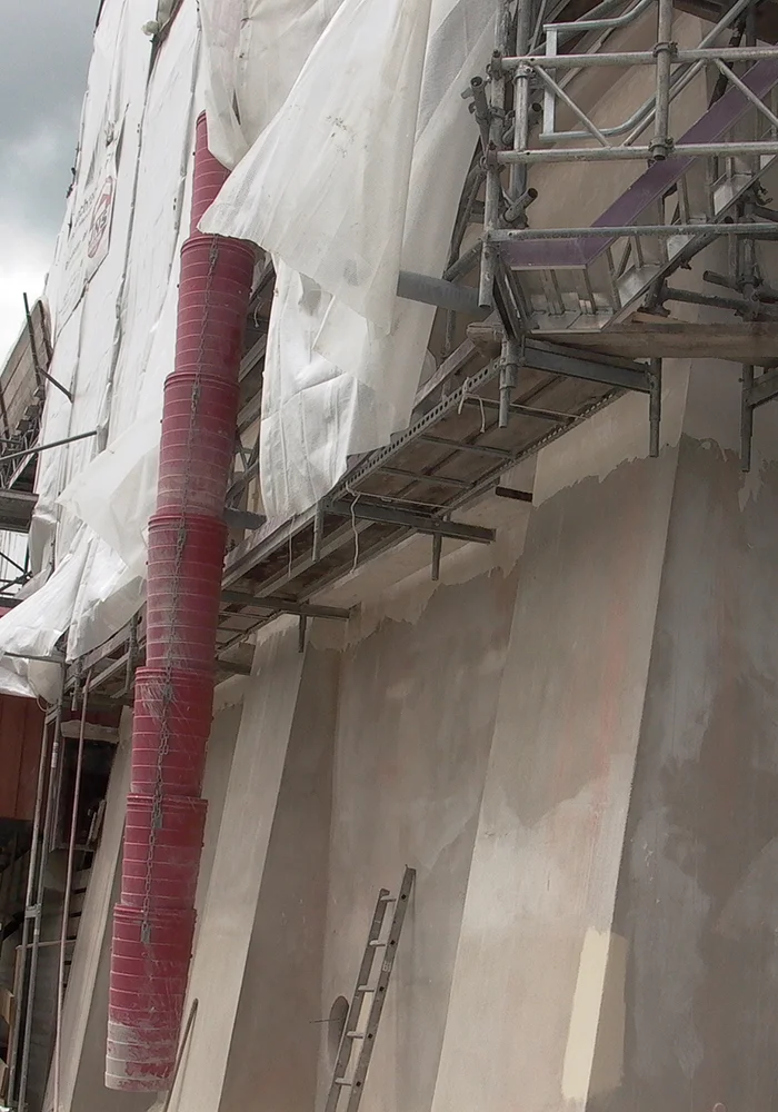 Gerüst und Schutzplanen an historischer Fassade während Sanierung der Außenwände